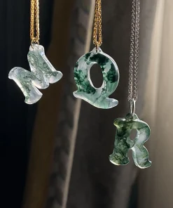Carved moss agate initial pendants showing letter examples M, Q and R