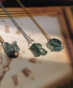 Moss agate initial pendants displayed flat on gold-colored and silver-colored chains