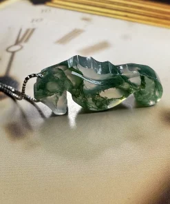 Rear view of moss agate seahorse pendant lying flat