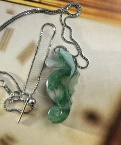 Carved moss agate seahorse necklace with chain and clasp displayed flat