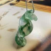 Hand-carved moss agate seahorse pendant showing curled tail and green mineral patterns
