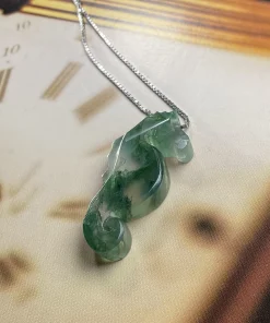 Moss agate seahorse pendant suspended above a clock-face background