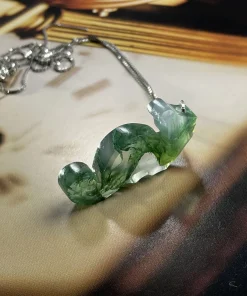Side view of carved moss agate seahorse pendant