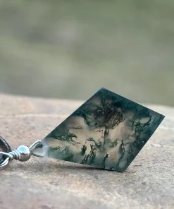 Rear view of diamond-shaped moss agate pendant on a dark cord