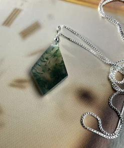 Diamond-shaped moss agate pendant displayed with a silver-colored chain