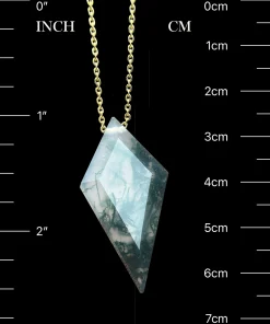 Faceted kite moss agate pendant beside inch and centimeter scale markings