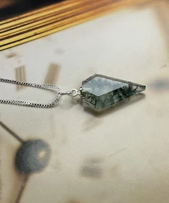 Side view of moss agate arrow pendant displayed flat with a box chain
