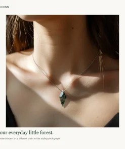 OLICONN poster showing kite moss agate necklace worn with an ivory top