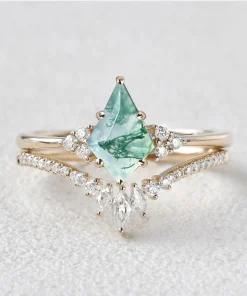 Pear moss agate engagement ring with clear accent stones and a curved matching band