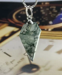 Angled view of prismatic moss agate pendant above a clock-face background