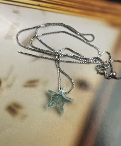 Moss agate star necklace with box chain and clasp displayed flat