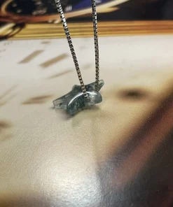 Side view of moss agate star pendant showing its carved thickness