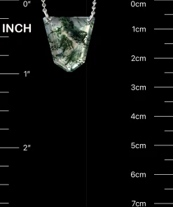 Shield-shaped moss agate pendant beside inch and centimeter scale markings