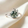 Hexagon moss agate leaf ring with polished botanical shoulders on ivory fabric
