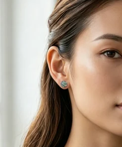 Hexagon moss agate stud earring worn on an ear
