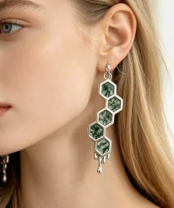 Honeycomb moss agate dangle earring worn on an ear