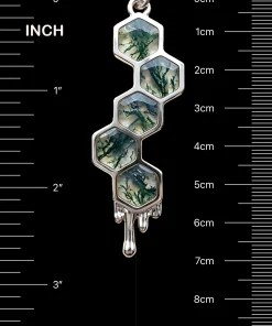 Honeycomb moss agate pendant beside inch and centimeter scale markings