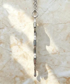 Side view of honeycomb moss agate pendant showing its slim gemstone frames