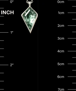Kite moss agate pendant beside inch and centimeter scale markings