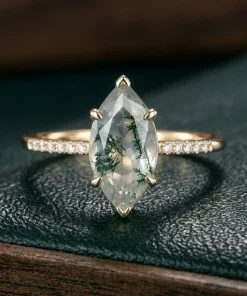 Front view of marquise moss agate ring with small clear shoulder accents