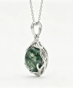 Angled view of organic moss agate pendant showing flowing frame and pendant loop