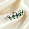 Five square moss agate gemstones arranged across a silver-colored band on ivory fabric