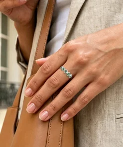 Square moss agate five-stone ring worn on a hand beside a tan bag