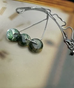 Three-disc moss agate necklace displayed flat with chain and clasp