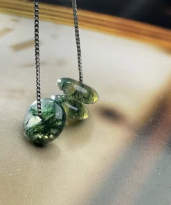 Three round moss agate discs suspended from a silver-colored box chain