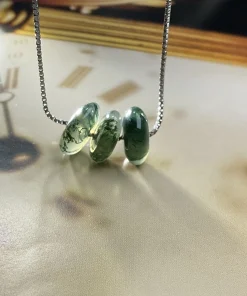 Side view of round moss agate disc necklace showing gemstone thickness