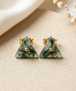 Triangle moss agate stud earrings with gold-colored central details on ivory fabric