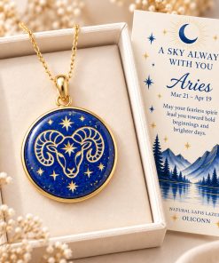 Aries zodiac necklace featuring a polished natural lapis lazuli pendant with gold Aries constellation design, displayed in an ivory jewelry box with a matching zodiac gift card