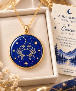 Cancer zodiac necklace featuring a polished natural lapis lazuli pendant with gold Cancer constellation design, displayed in an ivory jewelry box with a matching zodiac gift card