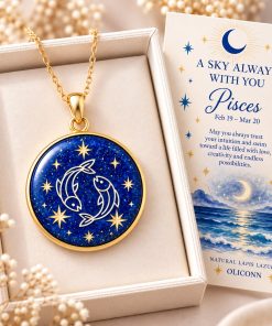 Pisces zodiac necklace featuring a polished natural lapis lazuli pendant with gold Pisces constellation design, displayed in an ivory jewelry box with a matching zodiac gift card