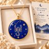 Scorpio zodiac necklace featuring a polished natural lapis lazuli pendant with gold Scorpio constellation design, displayed in an ivory jewelry box with a matching zodiac gift card
