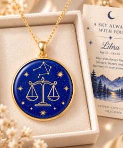 Libra zodiac necklace featuring a polished natural lapis lazuli pendant with gold Libra constellation design, displayed in an ivory jewelry box with a matching zodiac gift card