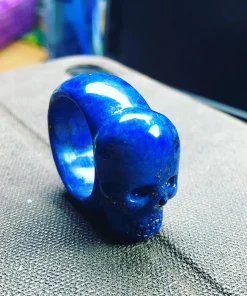 Angled view of lapis lazuli skull ring showing sculpted face and polished band