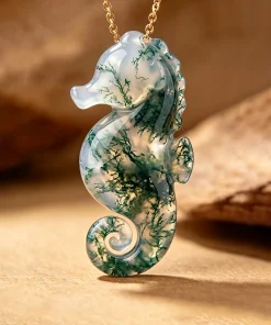 Front view of a seahorse pendant hand-carved from moss agate with branching green patterns