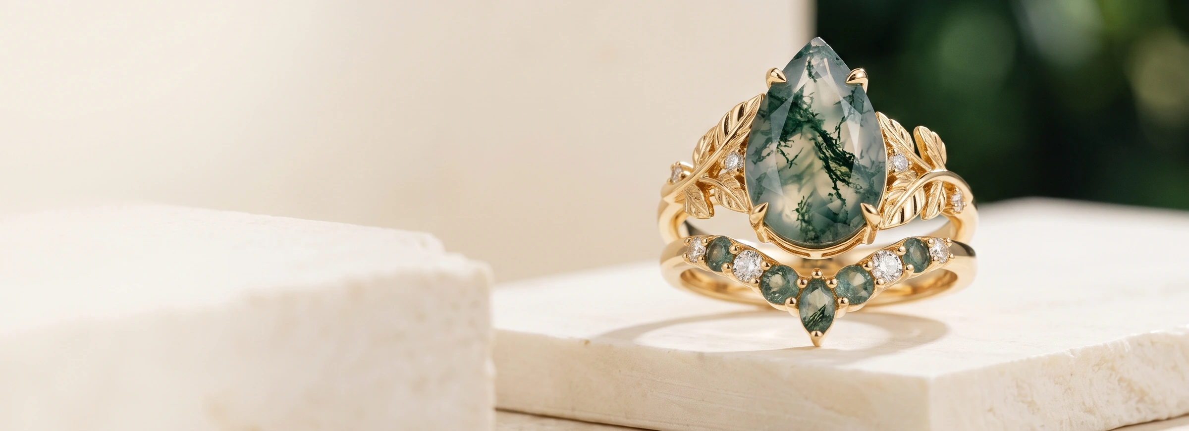 Illustrative gold botanical pear-shaped moss agate ring with a matching curved moss agate stacking band