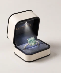 Cushion-cut moss agate ring in an open cream OLICONN box with blue-gray lining