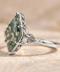 Side view of white gold kite moss agate leaf ring showing its raised setting