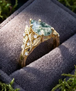 Side view of Sylvan Leaf ring showing its raised pear stone and botanical shoulders